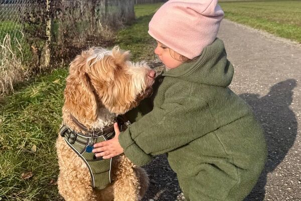 Reliable support for children, seniors and pets Small child with dog on a walking path, symbolising trust and closeness in care via KnowS.