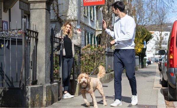 Pet owner handing her dog to a pet sitter in Zurich