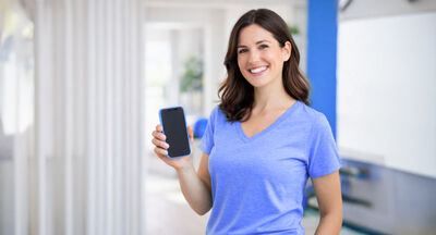 Frau zeigt ihr Smartphone und präsentiert ihre Dienstleistungen über KnowS